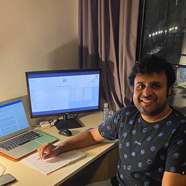 Aditya Prakash用笔记本电脑和屏幕在办公桌